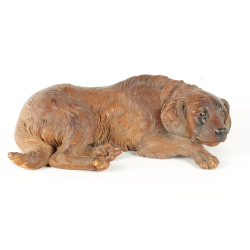 371 - AN 19TH CENTURY BLACK FOREST CARVED LINDEN WOOD SCULPTURE finely modelled as a recumbent dog with am... 