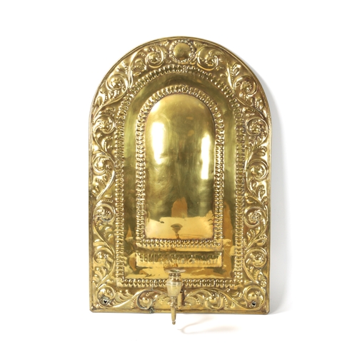 394 - AN 18TH CENTURY PRESSED BRASS WALL SCONCE with arched scrolled leafwork border and cushion centre; h... 