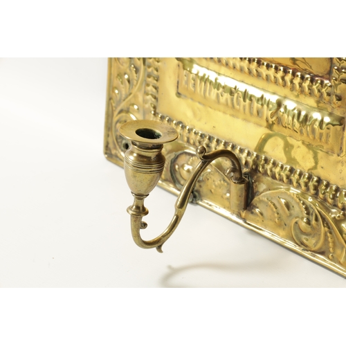 394 - AN 18TH CENTURY PRESSED BRASS WALL SCONCE with arched scrolled leafwork border and cushion centre; h... 