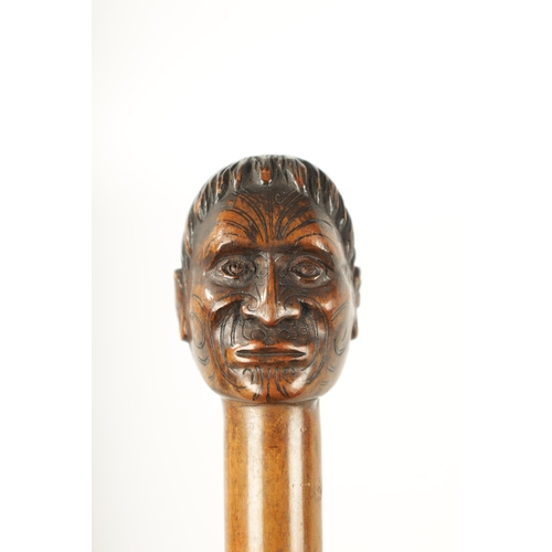 397 - A LATE 19TH CENTURY CARVED HARDWOOD WALKING STICK FORMED AS A MĀORI having facial decoration on a ta... 