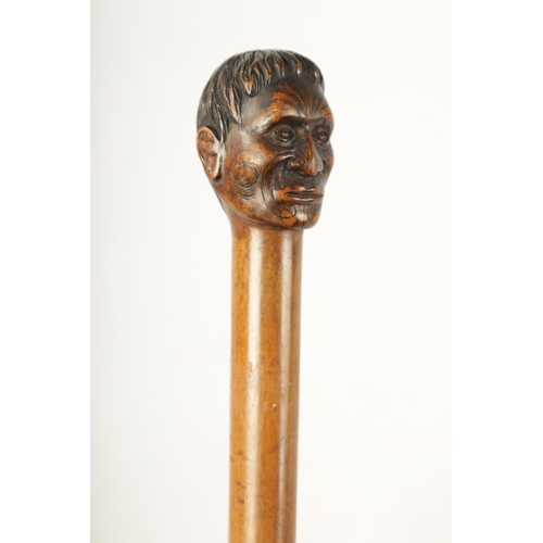 397 - A LATE 19TH CENTURY CARVED HARDWOOD WALKING STICK FORMED AS A MĀORI having facial decoration on a ta... 