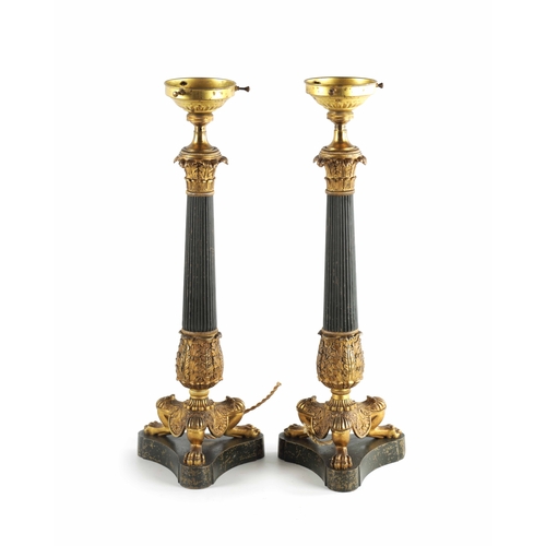 419 - A PAIR OF REGENCY STYLE BRONZE AND ORMOLU LAMP BASES with leaf cast reeded tapering stems; raised on... 