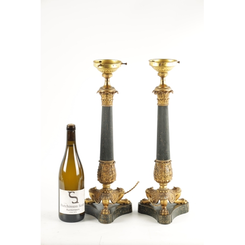 419 - A PAIR OF REGENCY STYLE BRONZE AND ORMOLU LAMP BASES with leaf cast reeded tapering stems; raised on... 