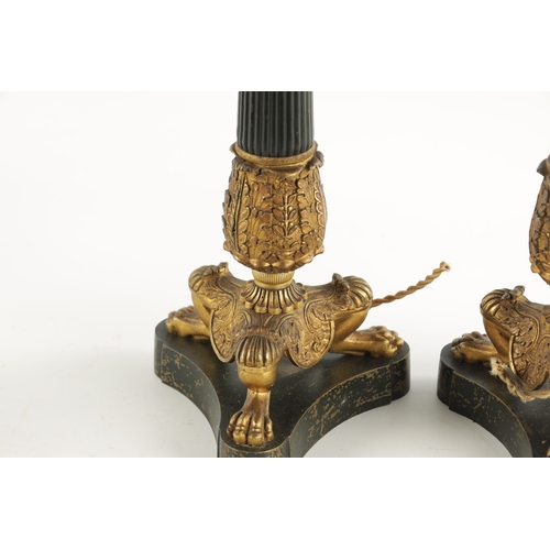 419 - A PAIR OF REGENCY STYLE BRONZE AND ORMOLU LAMP BASES with leaf cast reeded tapering stems; raised on... 