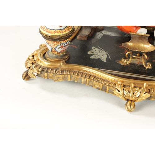 434 - A 19TH CENTURY CONTINENTAL ORMOLU, LACQUERWORK AND PORCELAIN PEN AND INK STAND with seated porcelain... 