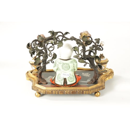 434 - A 19TH CENTURY CONTINENTAL ORMOLU, LACQUERWORK AND PORCELAIN PEN AND INK STAND with seated porcelain... 