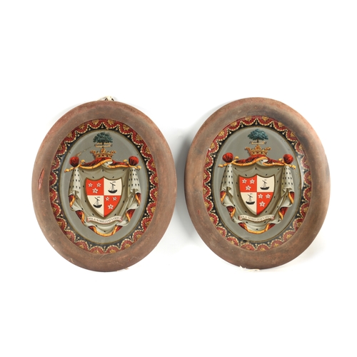 464 - A PAIR OF 19TH CENTURY FRAMED REVERSE PAINTED GLASS ARMORIAL PANELS the crested shield shaped inscri... 