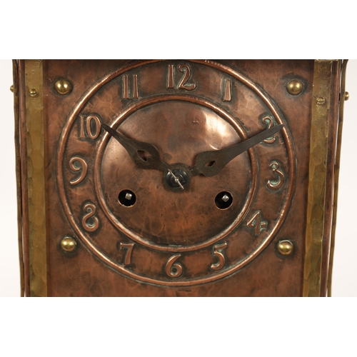 652 - AN ARTS AND CRAFT COPPER AND BRASS MANTEL CLOCK the planished case with domed top and relief Arabic ... 