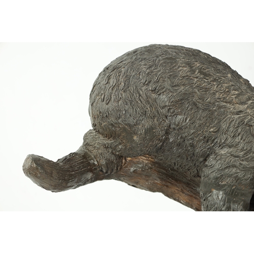 120 - A 20TH CENTURY BRONZE BEAR SCULPTURE depicting a bear sleeping in branch work; mounted on a black ma... 