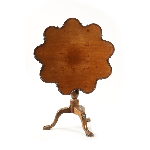 58 - A GEORGE III MAHOGANY TILT TOP TABLE with scalloped moulded edge top; raised on a carved cabriole ba... 