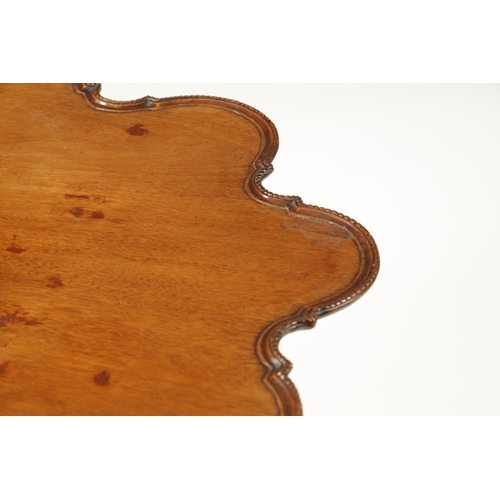 58 - A GEORGE III MAHOGANY TILT TOP TABLE with scalloped moulded edge top; raised on a carved cabriole ba... 