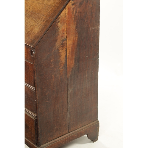 124 - AN EARLY 18TH CENTURY FIGURED OAK COUNTRY MADE BUREAU with fitted hinged fall above a bank of two sm... 