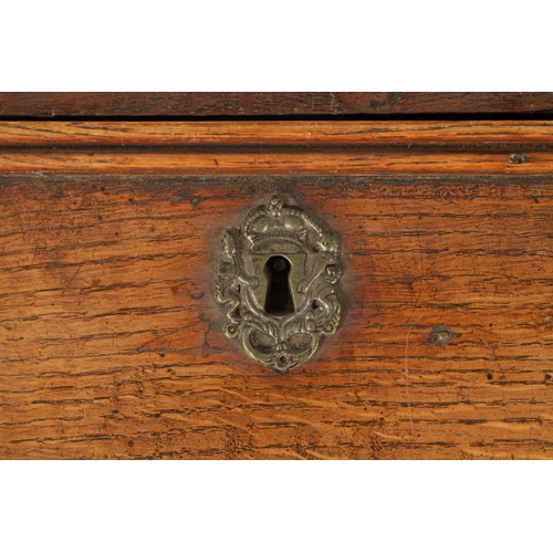 124 - AN EARLY 18TH CENTURY FIGURED OAK COUNTRY MADE BUREAU with fitted hinged fall above a bank of two sm... 