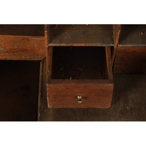 124 - AN EARLY 18TH CENTURY FIGURED OAK COUNTRY MADE BUREAU with fitted hinged fall above a bank of two sm... 