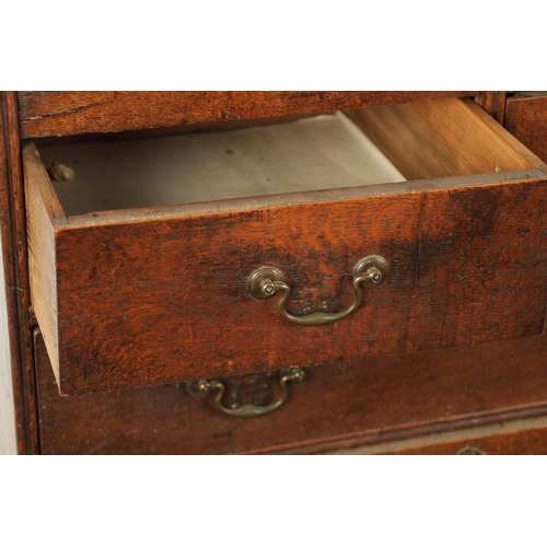 124 - AN EARLY 18TH CENTURY FIGURED OAK COUNTRY MADE BUREAU with fitted hinged fall above a bank of two sm... 