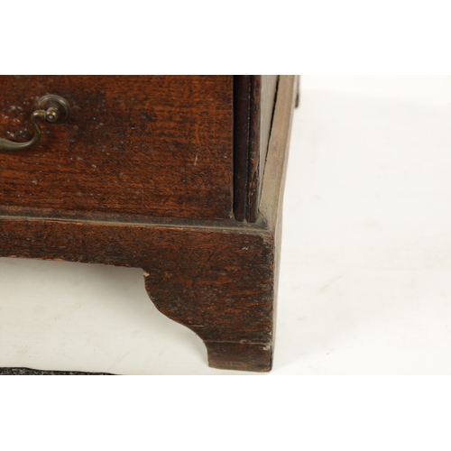 124 - AN EARLY 18TH CENTURY FIGURED OAK COUNTRY MADE BUREAU with fitted hinged fall above a bank of two sm... 