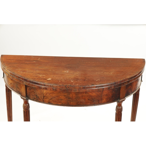 143 - A LATE 18TH CENTURY DEMI LUNE CARD TABLE ON FLUTED LEGS IN THE MANNER OF GILLOWS with cross-banded t... 