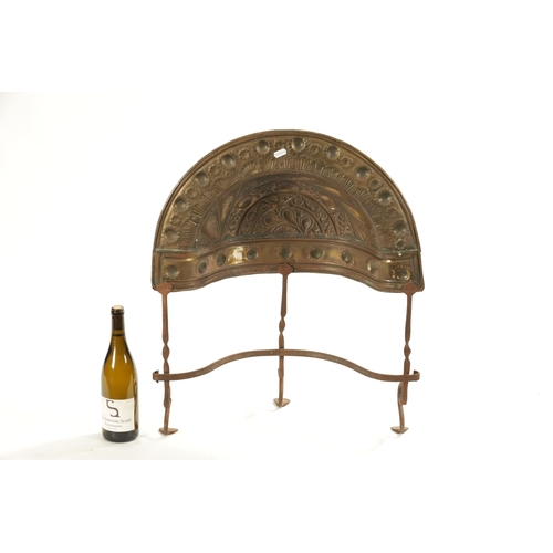 145 - AN 18TH CENTURY BRASS AND IRON CURFEW having an embossed dome top and iron legs (57cm wide 68cm high... 