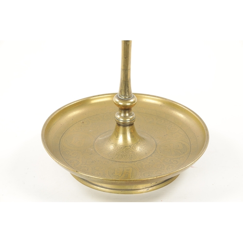 167 - A 19TH CENTURY EASTERN BRASS CANDLESTICK with circular engraved base. (52cm high)