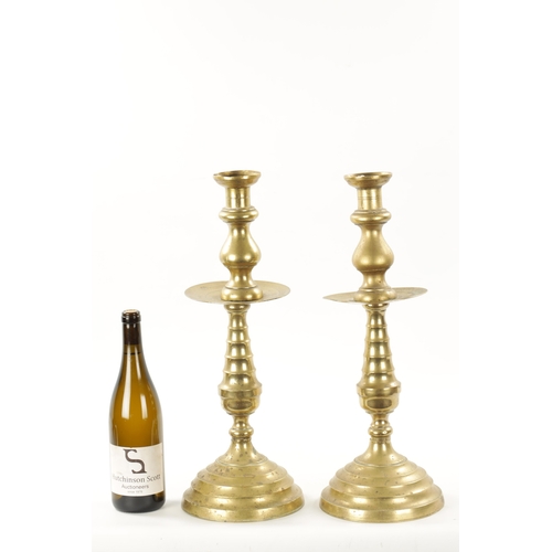 202 - A LARGE PAIR OF 18TH CENTURY BRASS CANDLESTICKS of rippled baluster form and centre drip trays