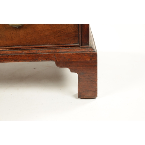 21 - A SMALL GEROGE III FIGURED MAHOGANY BACHELORS CHEST with fold over top above a bank of four drawers ... 