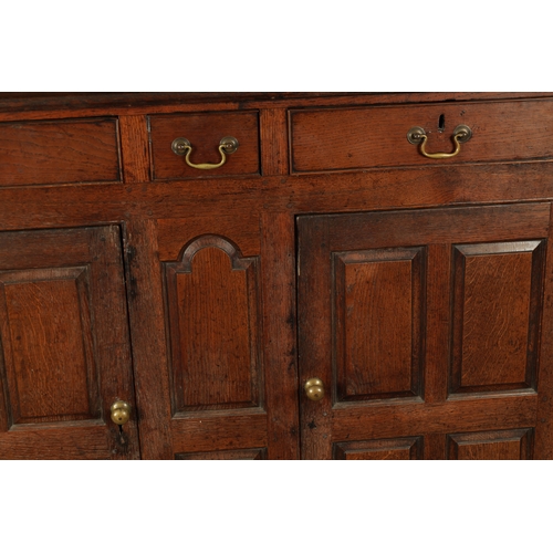 224 - AN EARLY 18TH CENTURY PANELLED OAK DUDARN with fielded panelled doors and frieze drawers (139cm wide... 