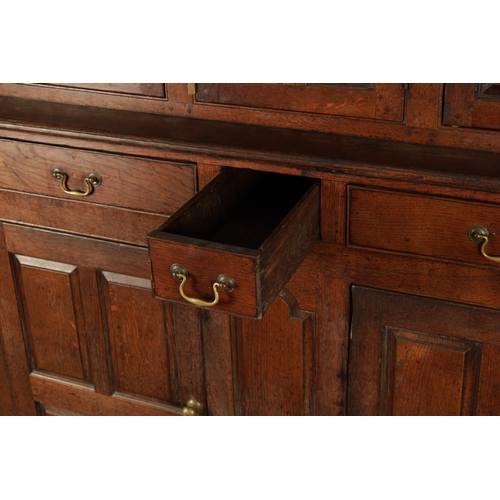 224 - AN EARLY 18TH CENTURY PANELLED OAK DUDARN with fielded panelled doors and frieze drawers (139cm wide... 