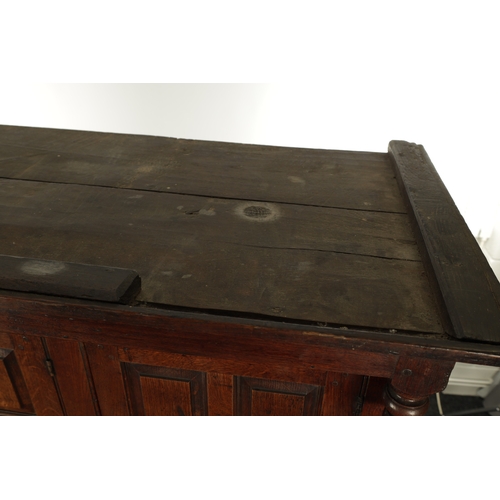 224 - AN EARLY 18TH CENTURY PANELLED OAK DUDARN with fielded panelled doors and frieze drawers (139cm wide... 