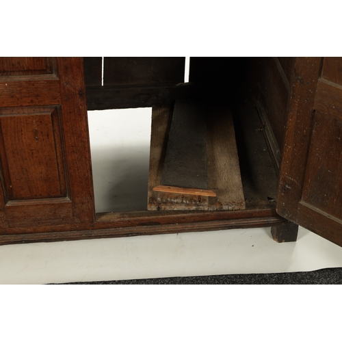 224 - AN EARLY 18TH CENTURY PANELLED OAK DUDARN with fielded panelled doors and frieze drawers (139cm wide... 