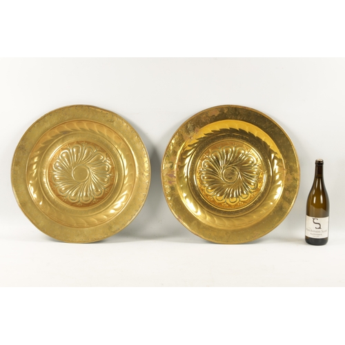 239 - A PAIR OF 17TH CENTURY BRASS ALMS DISHES with embossed swirl work decoration (49cm diameter)