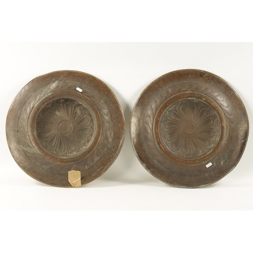 239 - A PAIR OF 17TH CENTURY BRASS ALMS DISHES with embossed swirl work decoration (49cm diameter)