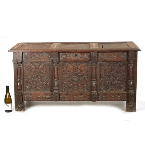 261 - A 17TH CENTURY CARVED OAK THREE PANELLED FRONT COFFER with panelled top and stile feet (141cm wide 6... 