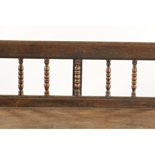 3 - AN EARLY 18TH CENTURY OAK SPINDLE BACK BENCH with plank seat; raised on splayed legs (289cm long 92c... 