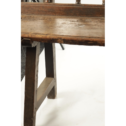 3 - AN EARLY 18TH CENTURY OAK SPINDLE BACK BENCH with plank seat; raised on splayed legs (289cm long 92c... 