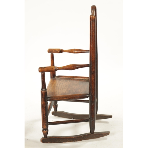 300 - A 19TH CENTURY ELM CHILD'S SPINDLE BACK ROCKING CHAIR with solid seat (70cm high 42cm wide)