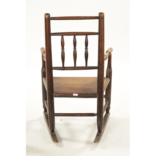 300 - A 19TH CENTURY ELM CHILD'S SPINDLE BACK ROCKING CHAIR with solid seat (70cm high 42cm wide)