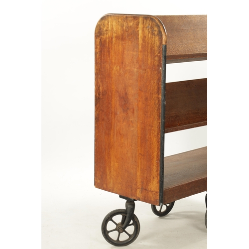 312 - AN EDWARDIAN OAK LIBRARY BOOKCASE ON WHEELS having double sided open shelves (91cm wide 42cm deep 10... 