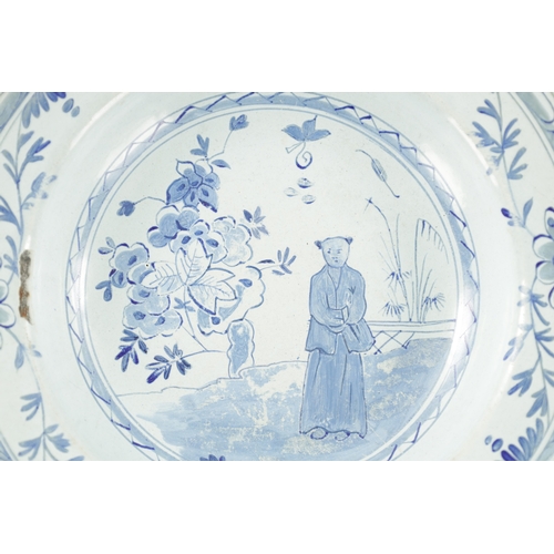 341 - AN 18TH CENTURY TINWARE BLUE AND WHITE DELFT STYLE PLATE with oriental figure and flowering trees (2... 