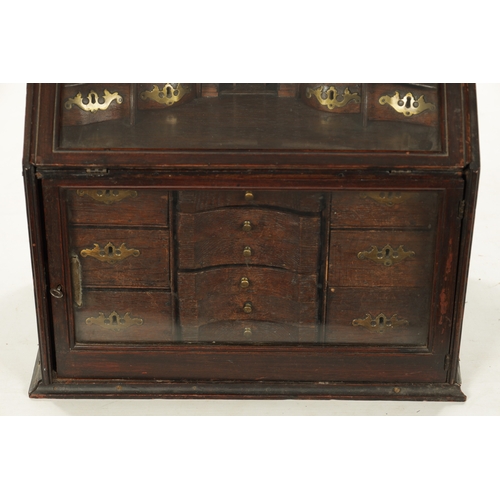 362 - AN 18TH CENTURY APPRENTICE MINIATURE BUREAU BOOKCASE with hinged glazed doors and fitted small drawe... 