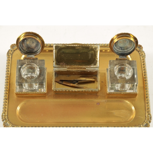 371 - A 19TH CENTURY BRASS DESKTOP INKWELL with two glass inkwells and recessed pen trays (27cm wide 19cm ... 