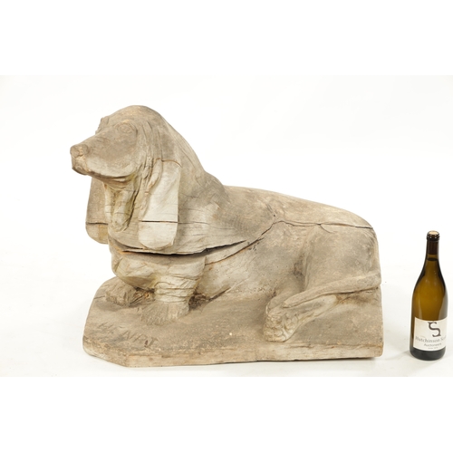 413 - A 19TH CENTURY CARVED WOOD SCULPTURE OF A SEATED DOG inscribed on base 'Henri' (73cm wide 45cm deep ... 