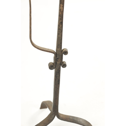 419 - AN 18TH / 19TH CENTURY CAST IRON CANDLESTICK with scrolled decoration and tripod base (63cm high)