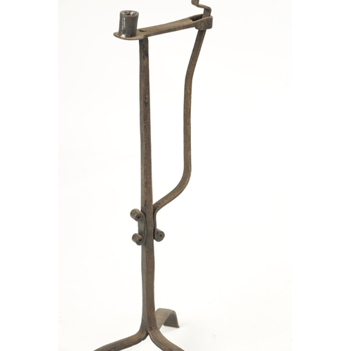 419 - AN 18TH / 19TH CENTURY CAST IRON CANDLESTICK with scrolled decoration and tripod base (63cm high)