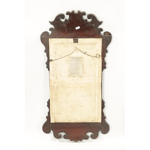 424 - A SMALL 18TH CENTURY WALNUT HANGING MIRROR with gilt shell pediment and shaped surround (80cm high 4... 