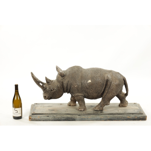 425 - AN UNUSUAL CARVED STONE / MARBLE SCULPTURE OF A RHINO on a hardwood base. (84cm wide 30cm deep 37cm ... 