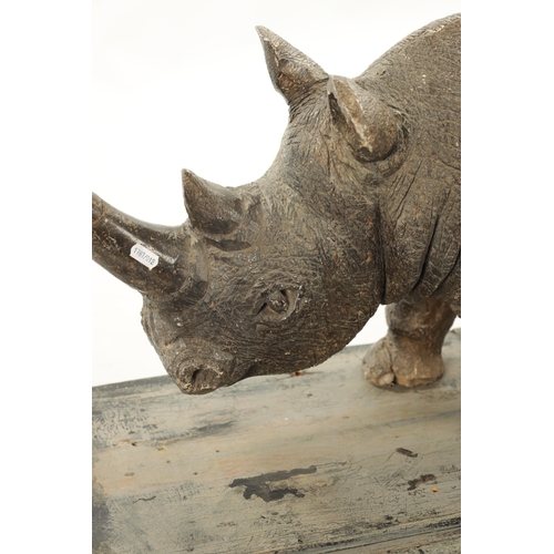 425 - AN UNUSUAL CARVED STONE / MARBLE SCULPTURE OF A RHINO on a hardwood base. (84cm wide 30cm deep 37cm ... 