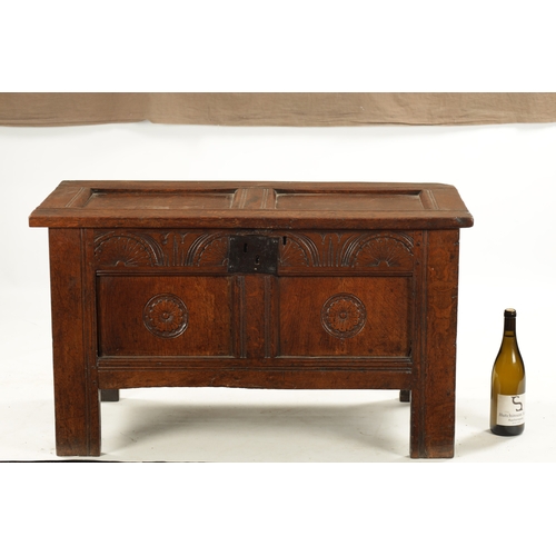 43 - A SMALL 17TH CENTURY OAK TWO PANEL COFFER with carved top rail and raised on stile feet (95cm wide 4... 