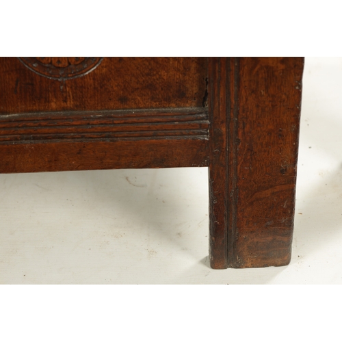 43 - A SMALL 17TH CENTURY OAK TWO PANEL COFFER with carved top rail and raised on stile feet (95cm wide 4... 