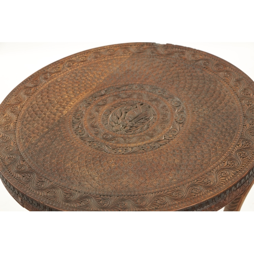 436 - A 19TH CENTURY INDIAN CARVED HARDWOOD OCCASIONAL TABLE the circular carved top above three elephant'... 