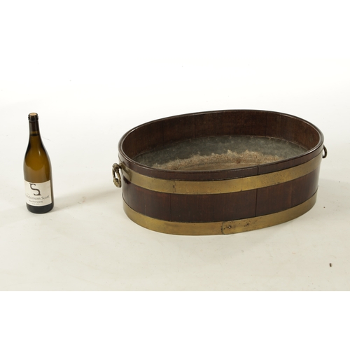 44 - A GEORGE III OVAL BRASS BOUND MAHOGANY WINE COOLER with fitted side handles (64cm wide 44cm deep 20c... 